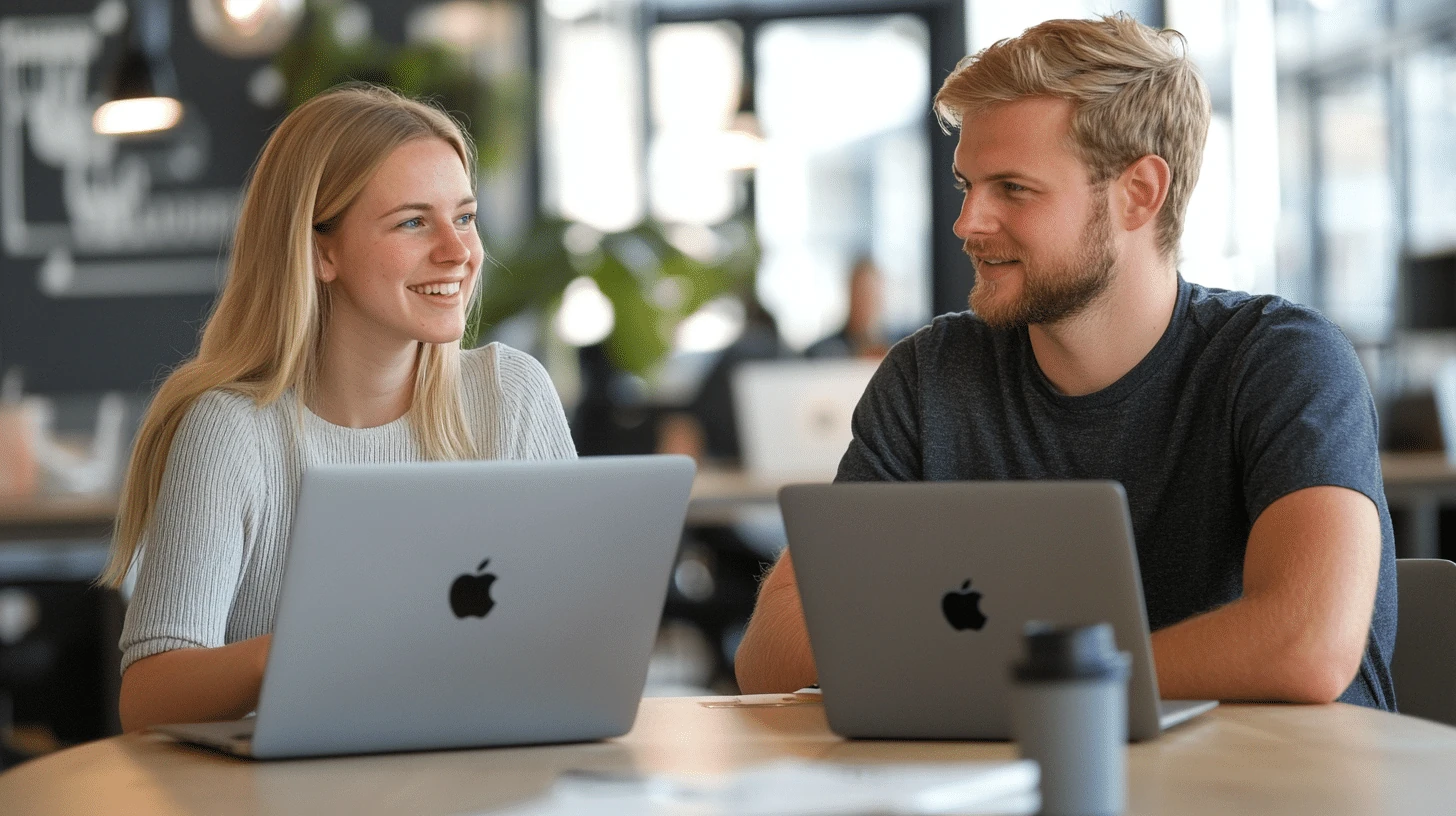 Dwóje programistów - facet i dziewczyna siedzaca przy stole w zespole creationX